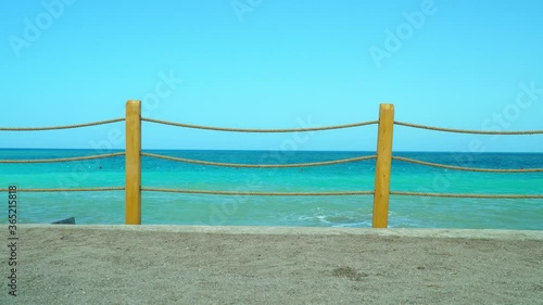 Sea panorama behinde the rope fence. Sand beach. photo