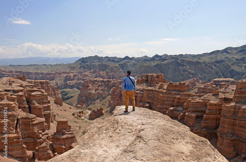 Man standing on a rock overseeing the magnificent landscape of Charyn Canyon, Kazakhstan