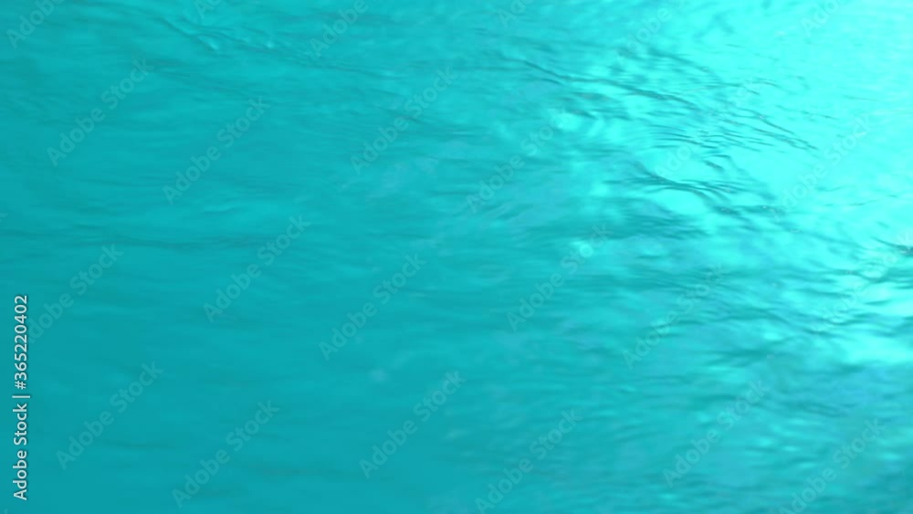 Beautiful sparkling shiny texture of blurry blue water with sun reflected on surface of water Beautiful sparkling shiny texture of blurry blue water with sun reflected on surface of water