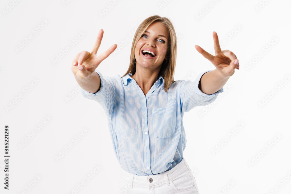 Image of happy blonde woman showing peace sign and smiling at camera Image of happy blonde woman showing peace sign and smiling at camera
