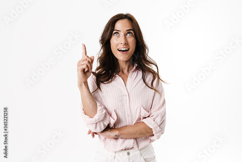 Image of happy brunette woman smiling while pointing finger upward