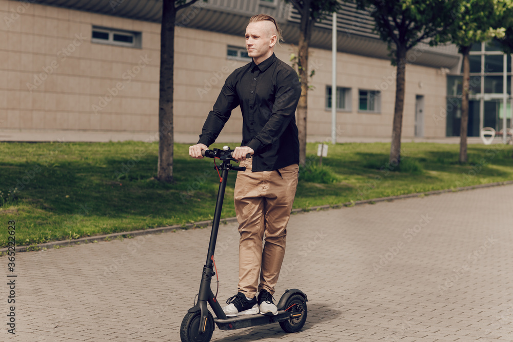 The young man rides an electric scooter around the city. The latest technology concept, the development of science and technology The young man rides an electric scooter around the city. The latest technology concept, the development of science and technology