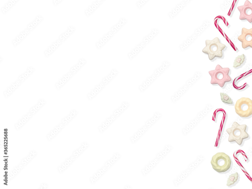 Fototapeta premium Candy canes and meringue on the right side of the frame on a white isolated background white / red and green Christmas candies. Space for text,