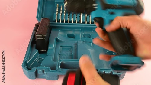 case with a screwdriver and nozzles on a pink background