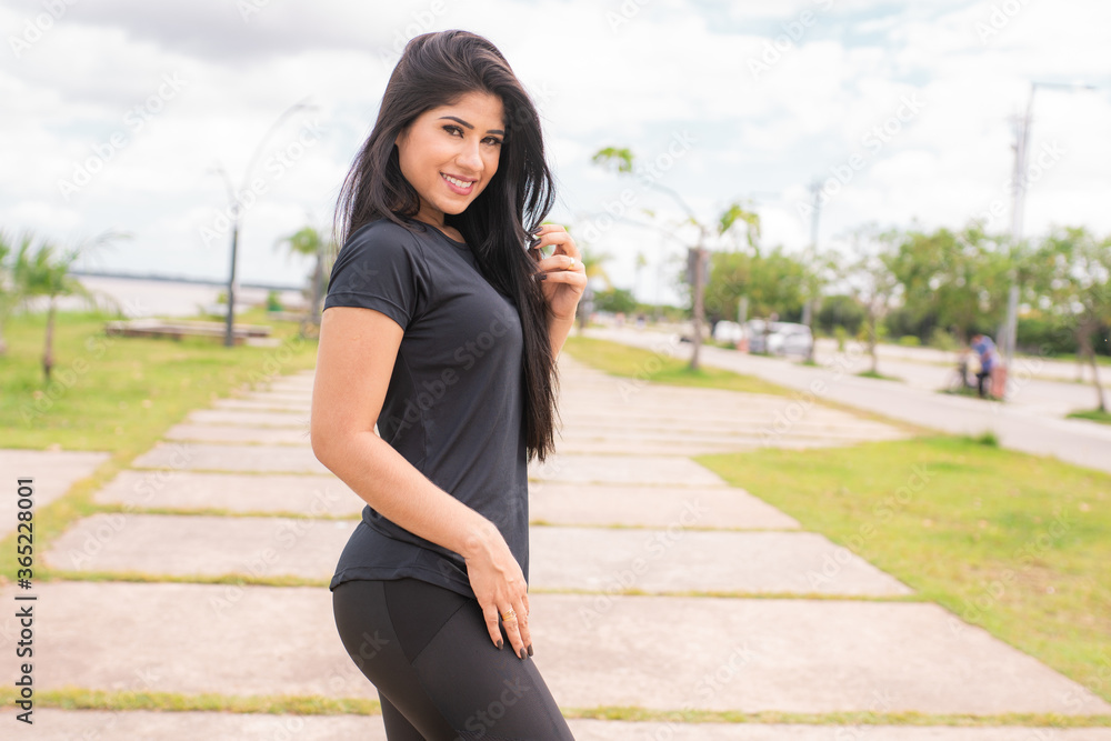 Fototapeta premium Mulher jovem e bonita posando para a câmera depois da corrida.