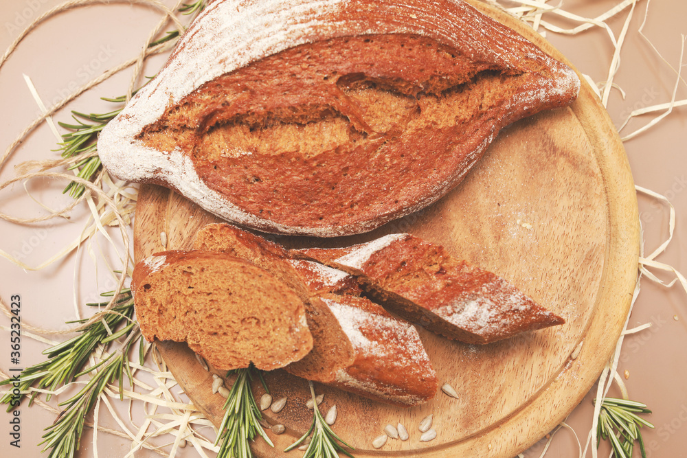 Sliced homemade bread with rosemary on wooden cutting board Sliced homemade bread with rosemary on wooden cutting board