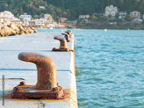 Foto Concrete mole in harbor with steel bollards