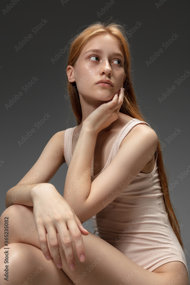 New look. Fashion portrait of beautiful redhead woman isolated on grey studio background. Concept of beauty, skin care, fashion and style. Artwork, modern and trendy portrait. Attractive model. New look. Fashion portrait of beautiful redhead woman isolated on grey studio background. Concept of beauty, skin care, fashion and style. Artwork, modern and trendy portrait. Attractive model.