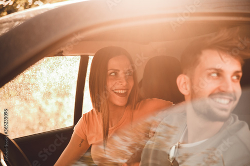 Coppia di fidanzati guarda fuori dal finestrino della loro auto con spontaneità mentre sono in viaggio con la loro automobile © Raffaele Conti RC88