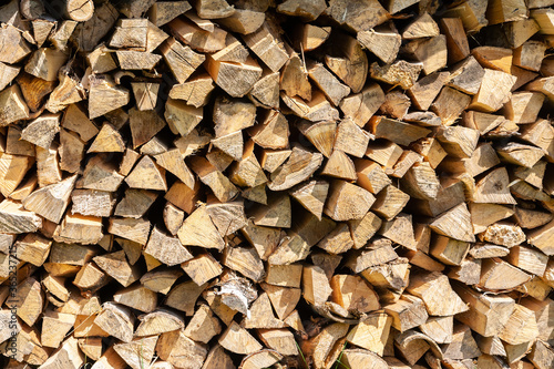 Dry birch firewood stacked for fireplace and stove. Close up view. Wooden background.