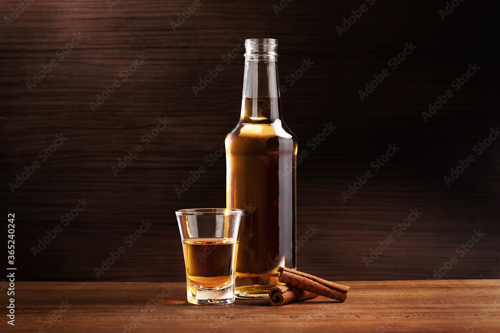 Cinnamon liqueur bottle with chalice and cinnamon sticks. Cinnamon liqueur bottle with chalice and cinnamon sticks.