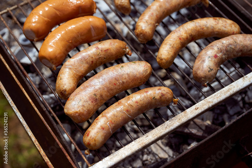 Homemade grilled meat sausages lie on the grill. Close-up.