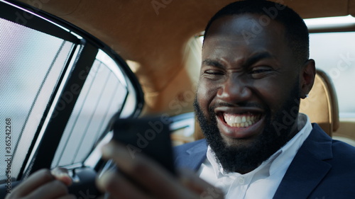 Portrait of winner african man business celebrating victory at luxury car. © stockbusters