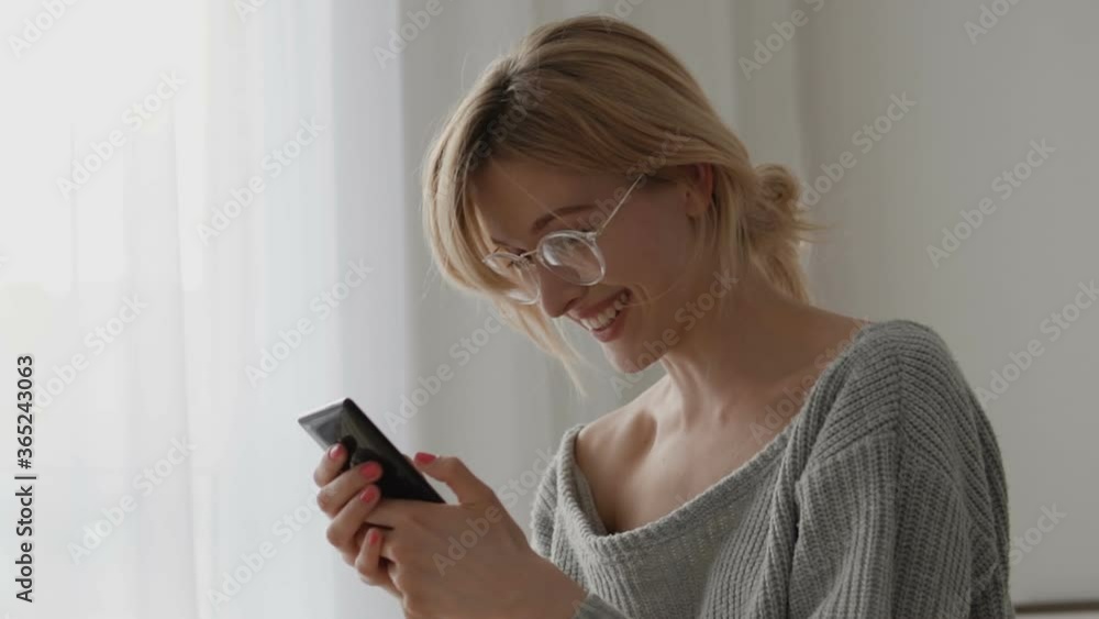 Surprised girl reading message on smartphone, happy smile on face, good news Surprised girl reading message on smartphone, happy smile on face, good news