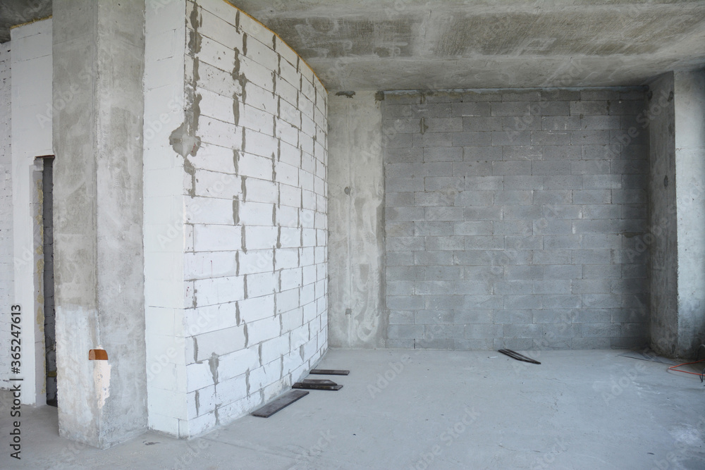 Beginning the renovation of a new apartment with concrete and brick walls in a new residential building. Beginning the renovation of a new apartment with concrete and brick walls in a new residential building.