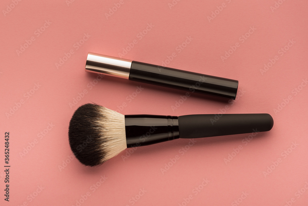 mascara, makeup brush on a pink surface top view mascara, makeup brush on a pink surface top view