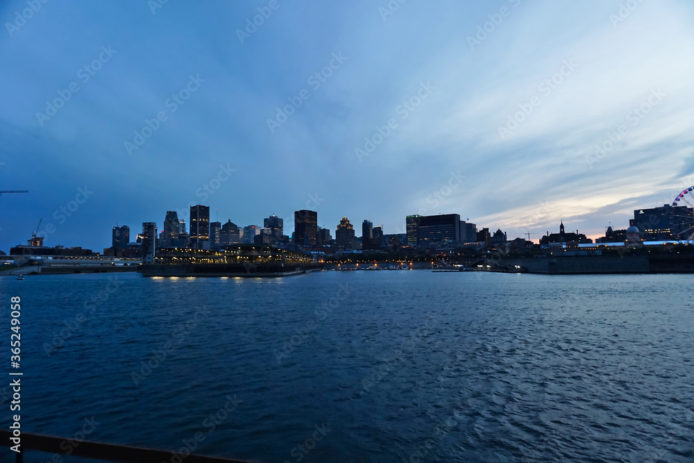 Montreal Downtown skyline during the twilight blue hour. Foreground is Saint Laurent river.