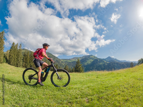 active senior woman riding her electric mountain bike in the Allgau Alps near city of Immenstadt, Algäu, Bavaria, Germany © Uwe