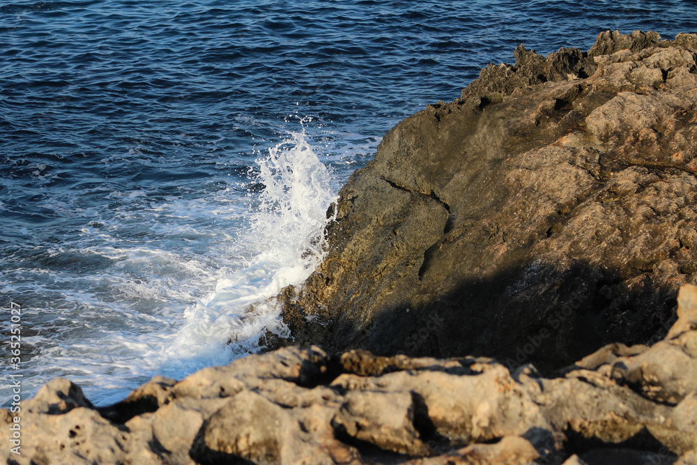 A wave breaking on the rocky shore, turning into white foam . Ayia Napa. Cyprus. A wave breaking on the rocky shore, turning into white foam . Ayia Napa. Cyprus.