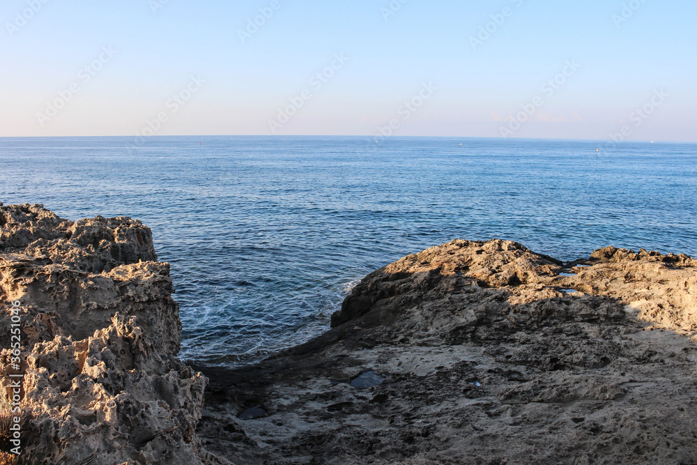 A lifeless stone beach against the blue sea and blue sky. Ayia Napa. Cyprus.