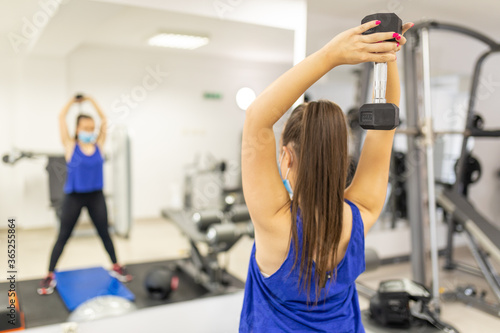 Woman training with medical facemask in gym. Female breathes deeply stock photo