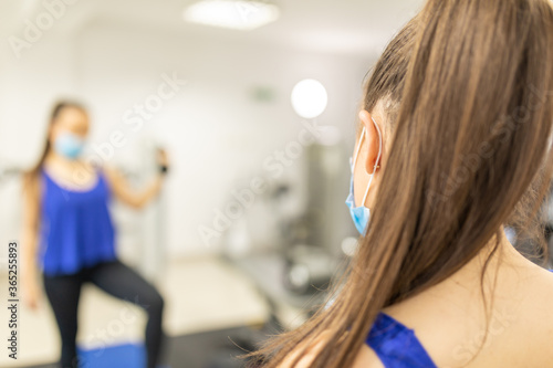 Woman training with medical facemask in gym. Female breathes deeply stock photo