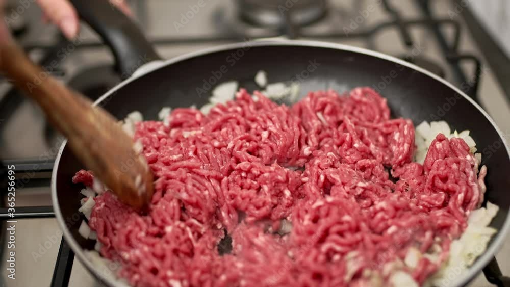 Frying in pan ground beef with onions and spices. Concept of preparing the beef for a burger in 4K. Frying in pan ground beef with onions and spices. Concept of preparing the beef for a burger in 4K.