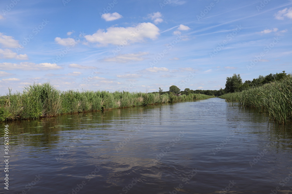 Beautiful view over Dutch water landscape during the summer with a beautiful blue sky and white clouds. Beautiful view over Dutch water landscape during the summer with a beautiful blue sky and white clouds.