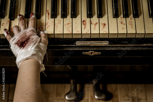 Bandaged and bloody hands of a pianist playing the piano