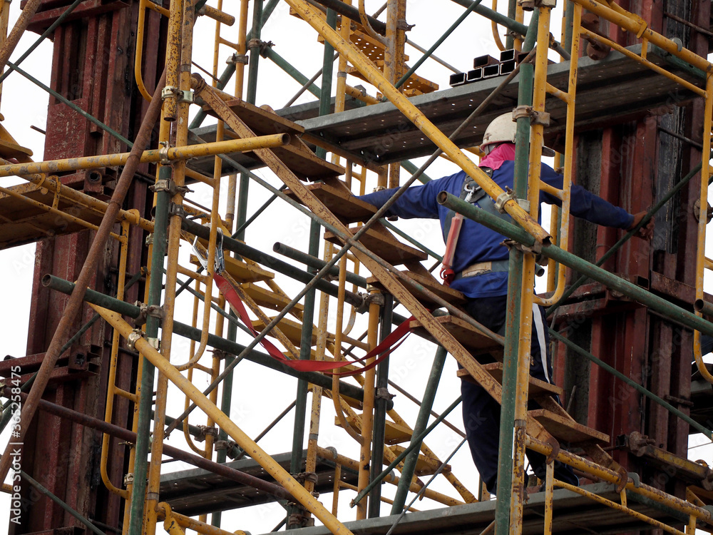Man Working on the Working at height on construction site with blue sky Man Working on the Working at height on construction site with blue sky