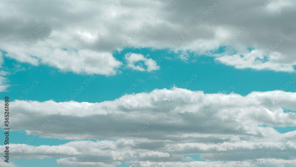 Panoramic photo of surreal cloudscape on vivid blue sky. Panorama of lined dreamy clouds.