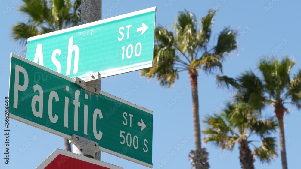 Pacific street road sign on crossroad, route 101 tourist destination, California, USA. Lettering on intersection signpost, symbol of summertime travel and vacations.Signboard in city near Los Angeles