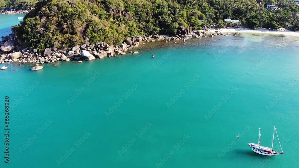 Naklejka premium Boat near tropical shore. Amazing drone view of modern yacht sailing on calm sea water near coast of tropical volcanic island. Exotic Paradise Koh Samui, Silver Beach.