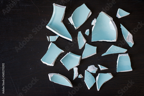 Canvastavla Shards of a broken light blue vase on a black surface