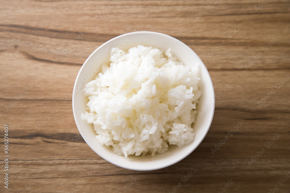 Bowl of boiled rice on wooden background, top view with space for text Bowl of boiled rice on wooden background, top view with space for text