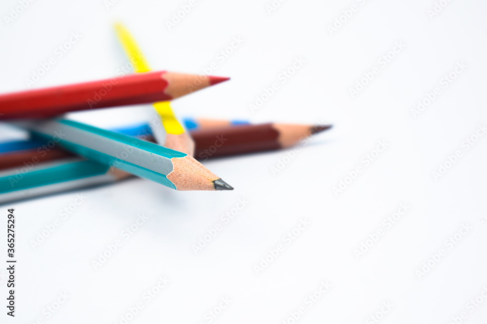 Five different colored wood pencil crayon scattered on a white background Five different colored wood pencil crayon scattered on a white background