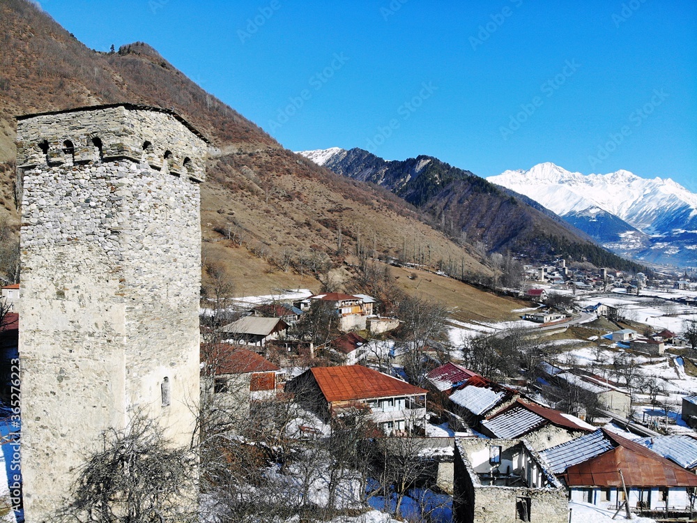 Fototapeta premium Winter Georgia. Svaneti Region, mountain city Mestia. Svan Towers. View from above, perfect landscape photo, created by drone. Aerial photo from travel.