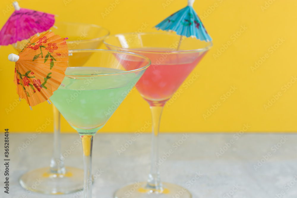 Glasses of various delicious fruit non-alcoholic cocktails on a bright background with umbrellas. Health drinks. Glasses of various delicious fruit non-alcoholic cocktails on a bright background with umbrellas. Health drinks.