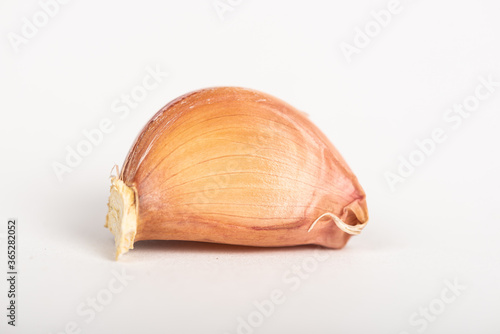 Garlic clove with shell on white background