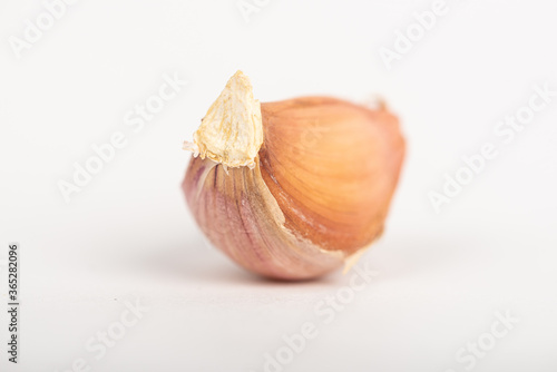 Garlic clove with shell on white background