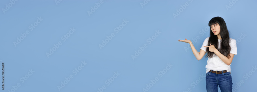 Showing, pointing. Portrait of young asian woman isolated on blue studio background. Beautiful cute girl in casual. Human emotions, facial expression, sales, ad, online shopping concept. Flyer Showing, pointing. Portrait of young asian woman isolated on blue studio background. Beautiful cute girl in casual. Human emotions, facial expression, sales, ad, online shopping concept. Flyer