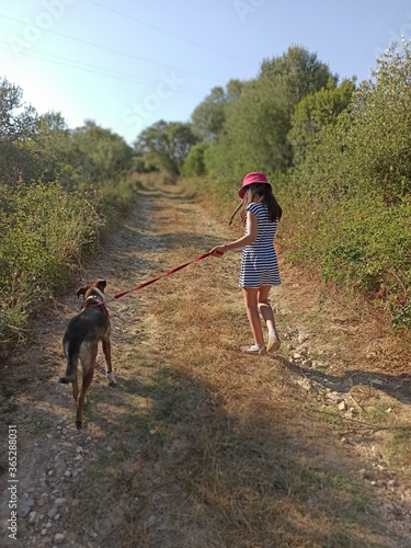 litle girl and dog walking in the woods © David