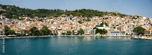 Fototapeta Naklejka Na Ścianę i Meble -  Panoramic view of the historical town on Skopelos island seen from the boat when entering the harbor in summer light.