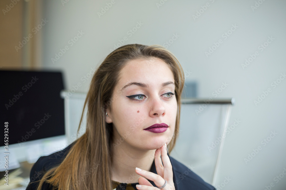 Ritratto di manager bionda con gli occhi chiari che guarda seduta nella propria postazione Ritratto di manager bionda con gli occhi chiari che guarda seduta nella propria postazione