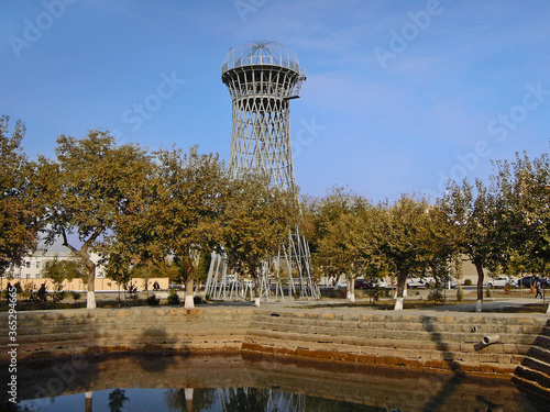Shukhov Tower in Bukhara, once used as water tower. Now it's not working and became the tourist sight. Tower is located near mosque Bolo Haouz and its pool, Bukhara, Uzbekistan