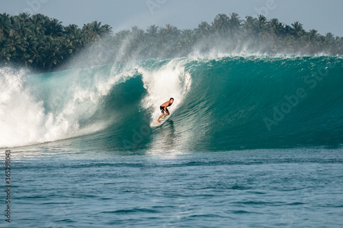 Surfer on perfect blue big tube wave, empty line up, perfect for surfing, clean water, Indian Ocean in Mentawai islands photo