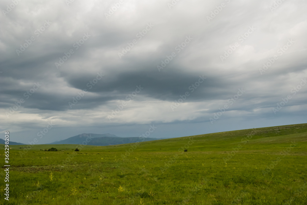 green hills under a dense cloudy sky