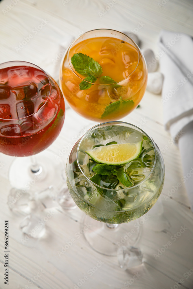 Assorted cold cocktails - mojito, orange and raspberry. On a wooden, white table
Assorted cold cocktails - mojito, orange and raspberry. On a wooden, white table