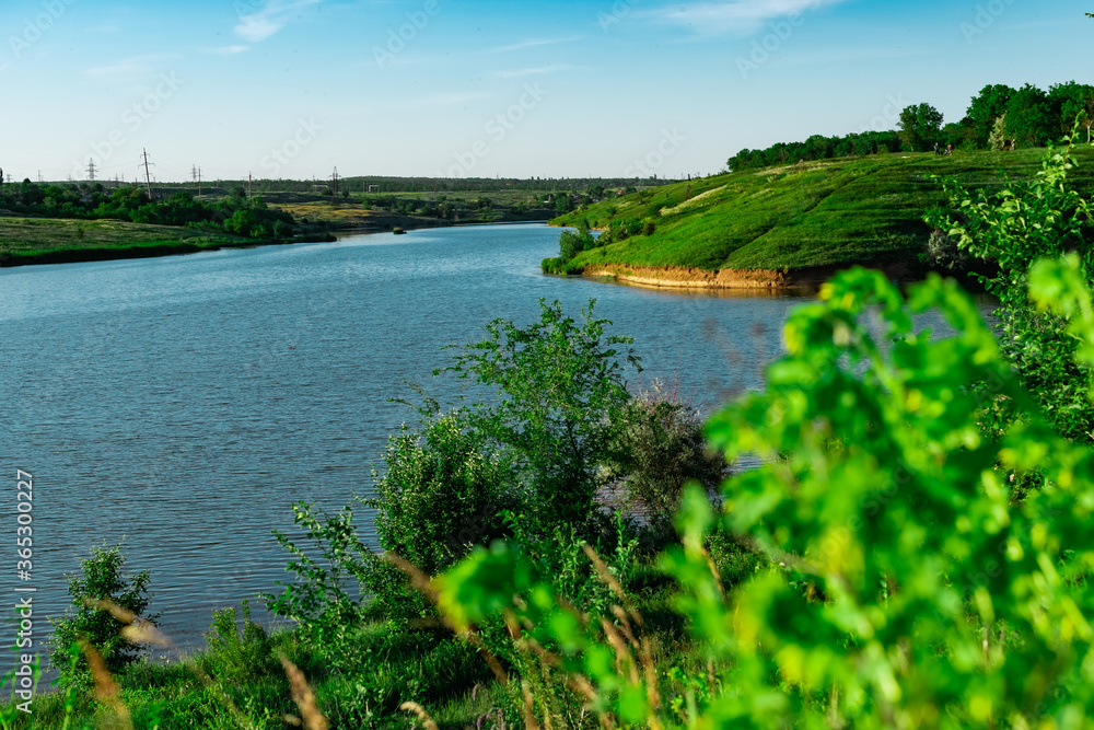 Landscape with a wide river and lots of green vegetation. Rostov oblast, the river Grushevka. Warm summer season, spring, everything blooms and smells, Sunny clear day