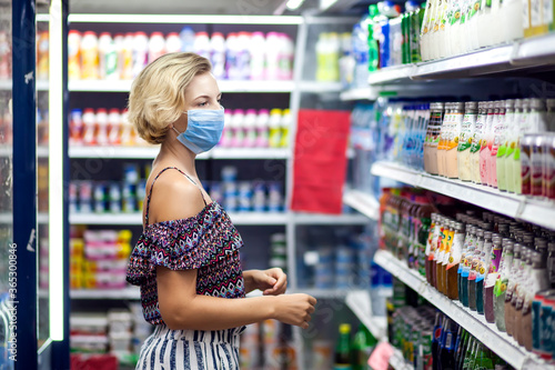 Woman with medical face mask doing one's shopping in the market. Life during coronavirus time